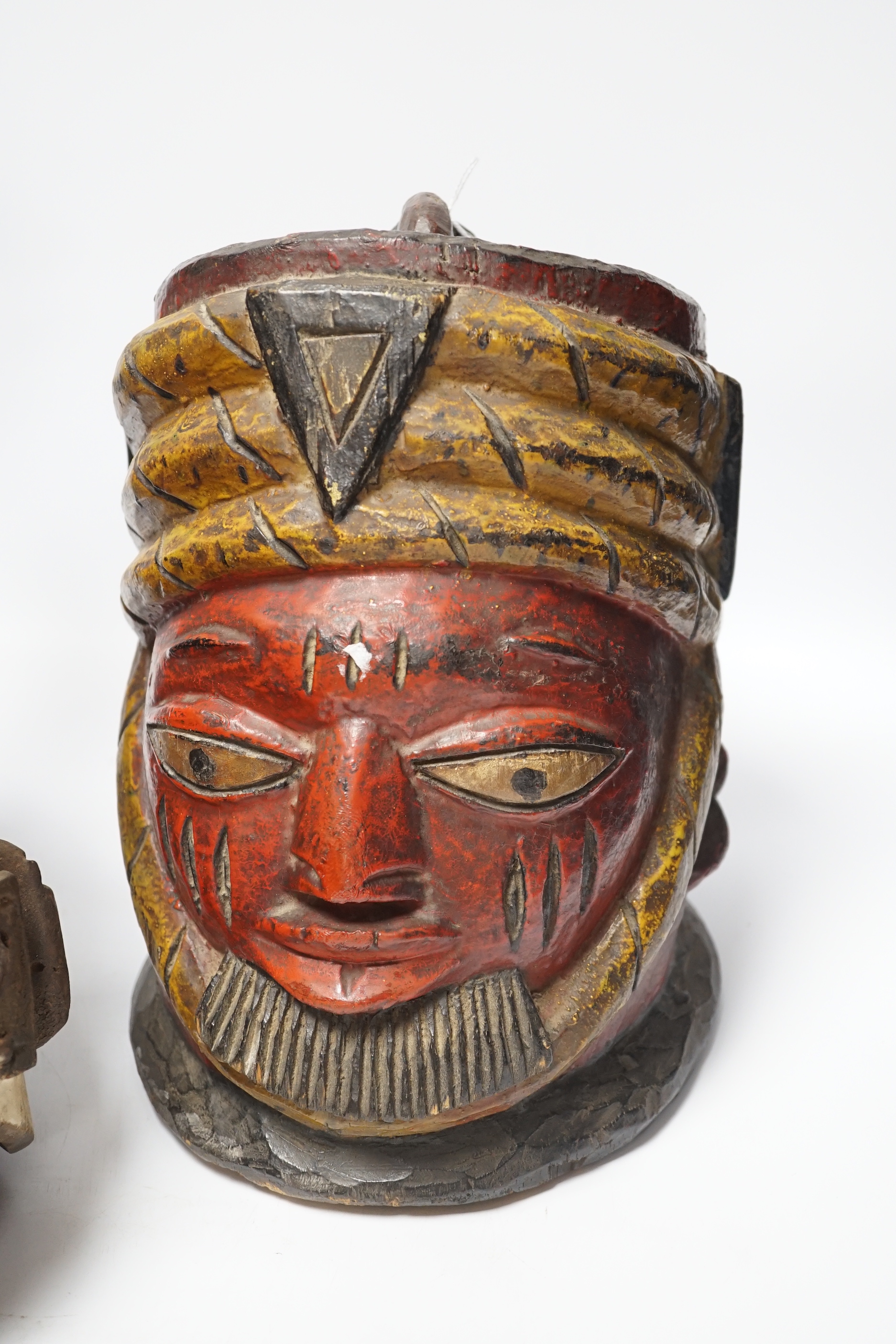 An Igbo maiden spirit mask and an African tribal helmet mask, largest 46cm wide